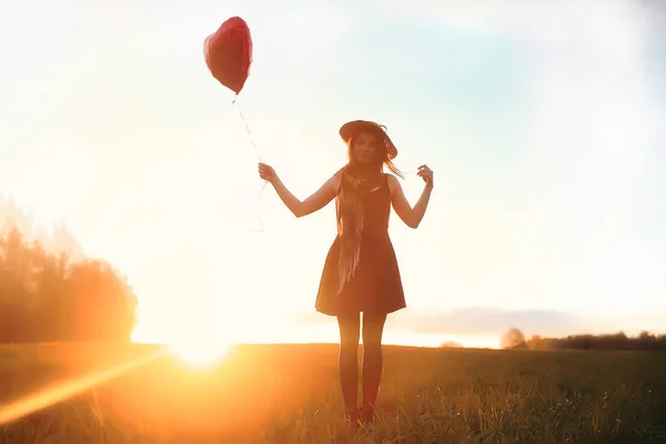 Una ragazza con un cappello mentre passeggia nel parco. Una ragazza con un cesto a piedi — Foto Stock