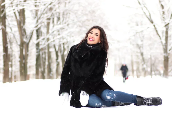 Μια νεαρή γυναίκα με τα πόδια σε ένα χειμερινό πάρκο — Φωτογραφία Αρχείου