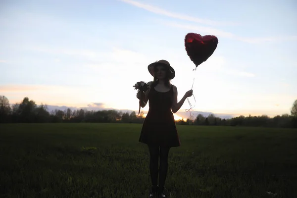 Uma rapariga de chapéu a passear no parque. Uma menina com um passeio de cesta — Fotografia de Stock