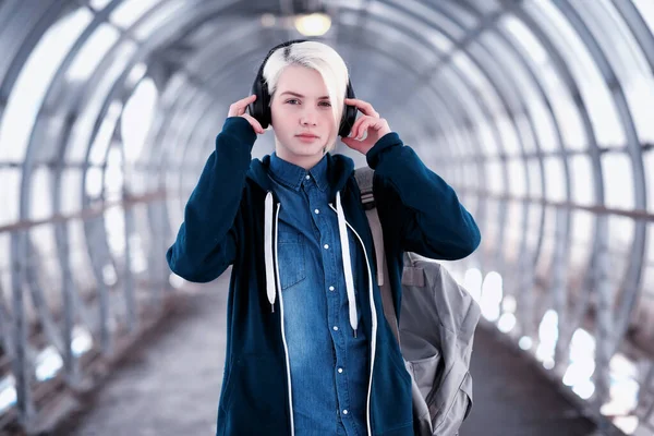 Joven estudiante escuchando música en grandes auriculares en el metro —  Fotos de Stock