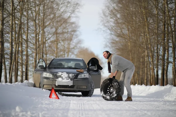 A man near a broken car on a winter day — Stock Photo, Image