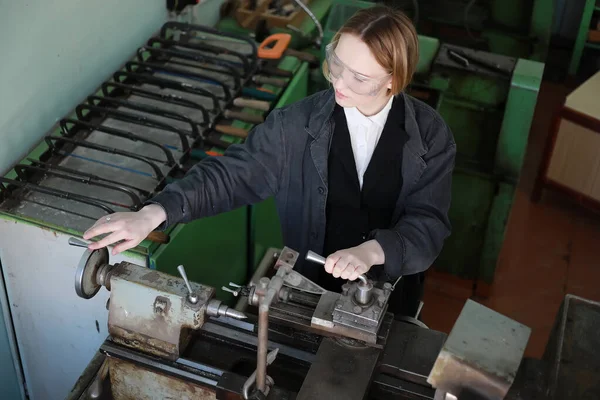 Young woman engineer working at machine tool — Stock Photo, Image