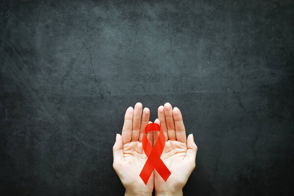 Symbol of human immunodeficiency virus disease. Red ribbon. A he