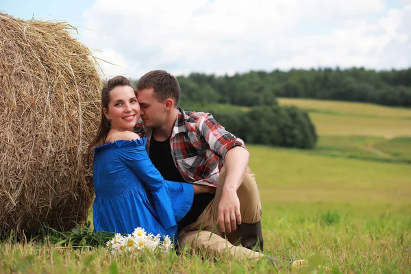 Couple amoureux dans un champ au coucher du soleil — Photo