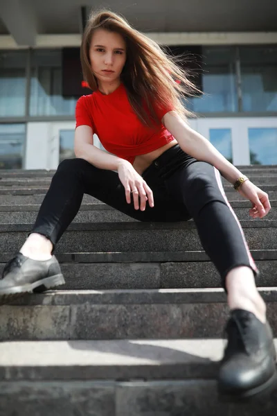 Ein Mädchen posiert auf den Stufen eines Gebäudes — Stockfoto
