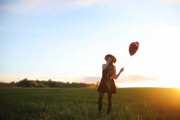 Una ragazza con un cappello mentre passeggia nel parco. Una ragazza con un cesto a piedi — Foto Stock