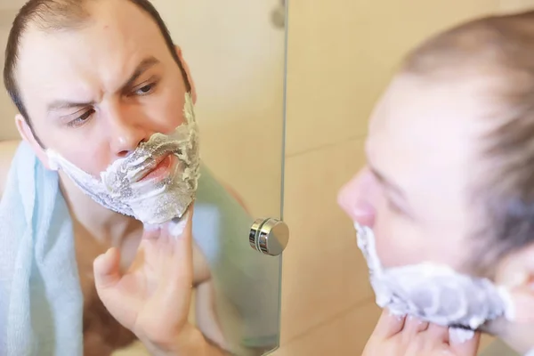 A man shaves in the bathroom in the morning — Stock Photo, Image