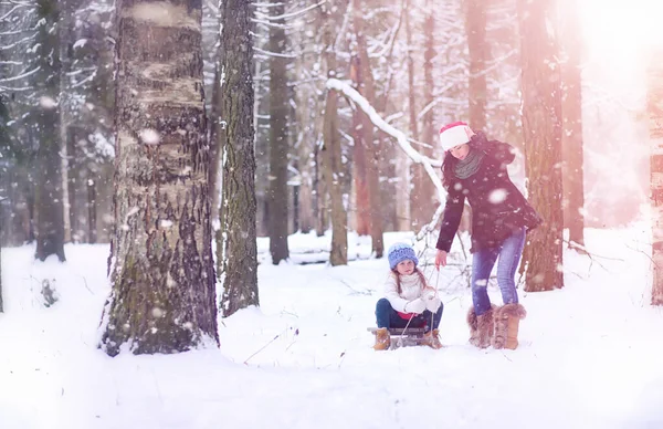 Un cuento de hadas de invierno, una joven madre y su hija montan en un trineo — Foto de Stock