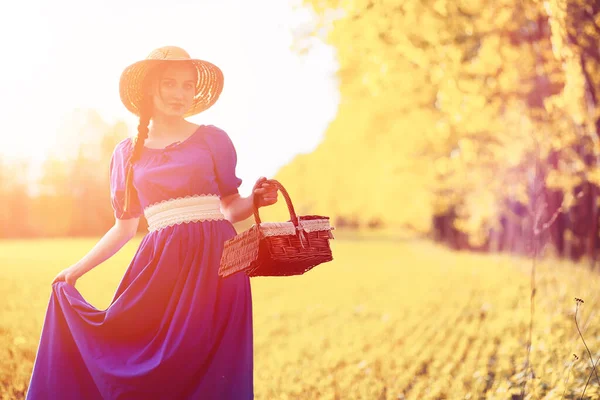 Gadis cantik muda dengan gaun di alam. Seorang gadis dengan topi berjalan — Stok Foto