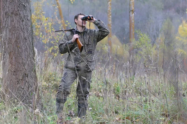 Hombre en camuflaje y con armas en un cinturón forestal en un hun de primavera — Foto de Stock