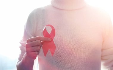 Kırmızı kurdele kızın. Kız kırmızı kurdele tutuyor. O