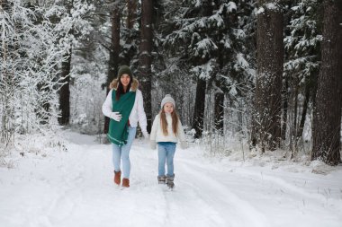 Genç bir aile yürüyüşe çıktı. Anne ve kızı şarapla yürüyorlar.