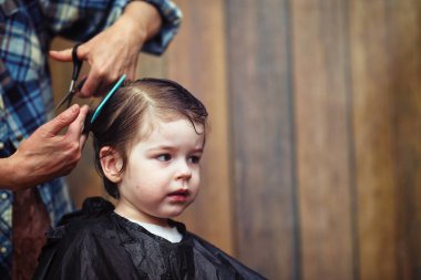 Küçük bir çocuk kuaförde kesilmiş. 