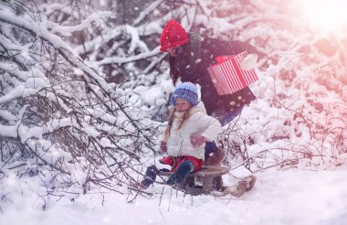 Bir kış masal, genç bir anne ve kızı bir kızak sürmek