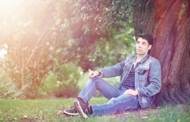 Genç bir adam öğle yemeği zamanında parkta yürür. Bir adam yürüyüşe çıktı. 