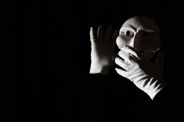 Siyah arka planda beyaz, korkunç bir maske..