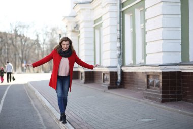 Şehirde kırmızı paltolu bir yolda güzel kız