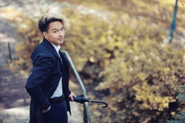 Sonbahar yağmurlu hava ve bir şemsiye ile genç bir adam