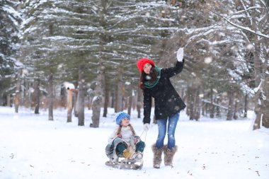 Bir kış masal, genç bir anne ve kızı bir kızak sürmek