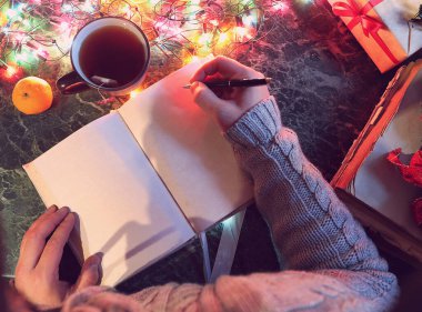 Yeni yıl masasında elinde boş bir kitapla oturan bir adam.