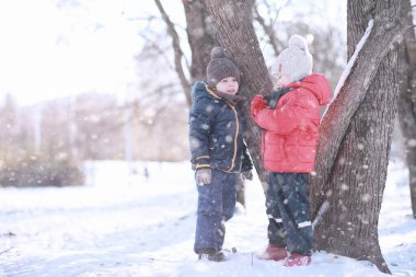 Çocuklar parkta kuşları besler. 