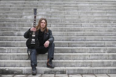 Basamaklarda rock gitaristi. Bir bas gitar bir müzisyenle bir 