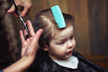Küçük bir çocuk kuaförde kesilmiş. 