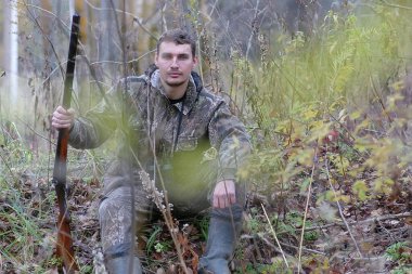 Kamuflaj ve bahar hun üzerinde orman Kuşağı'nda silahlı adam