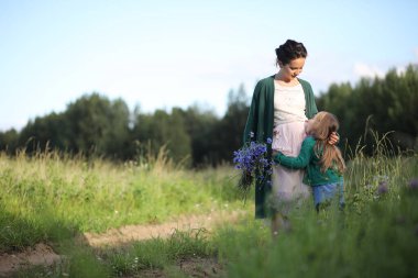 Anne ve kızı yolda yürüyor.