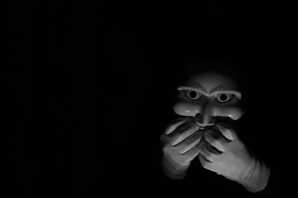 Máscara espeluznante blanca sobre fondo negro con mano blanca . — Foto de Stock