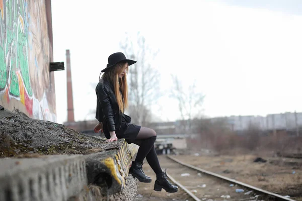En tjej går ner staden gatan i en läder väst med en — Stockfoto