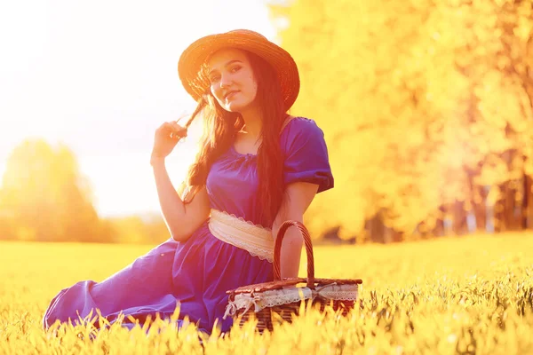 Gadis cantik muda dengan gaun di alam. Seorang gadis dengan topi berjalan — Stok Foto