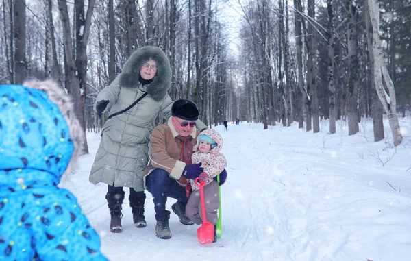 Gezin met kind wandeling in winter park besneeuwde — Stockfoto