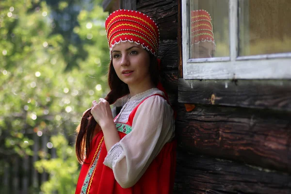 Slav woman in traditional dress wooden wall — Stock Photo, Image