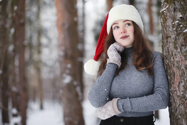 Mladá dívka ve winter parku na procházku. Vánoční svátky v t — Stock fotografie