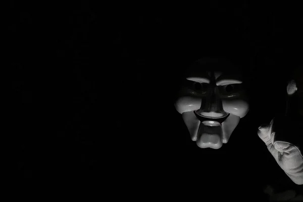 White scary mask on a black background with whites hand. — Stock Photo, Image