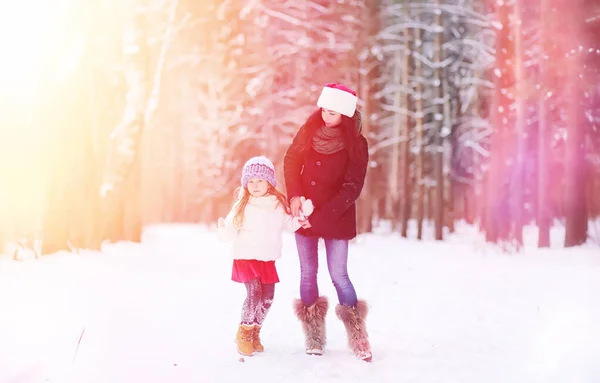 A winter fairy tale, a young mother and her daughter ride a sled — Stock Photo, Image