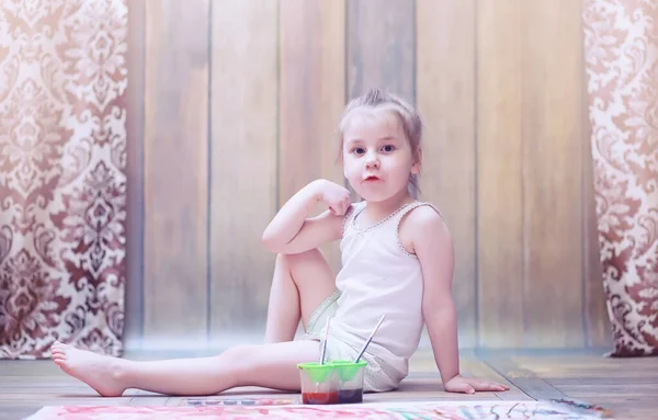 Niños pequeños pintan en una hoja grande de papel —  Fotos de Stock