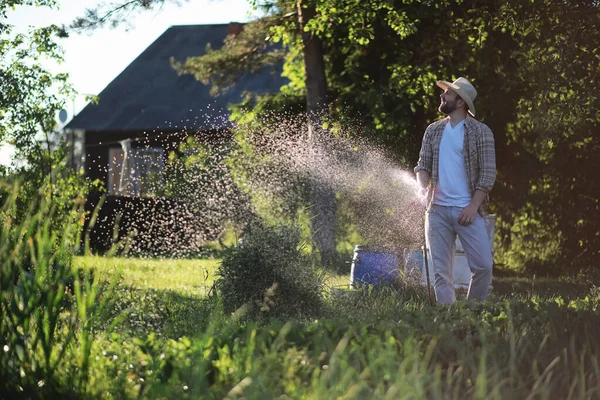 Hombre agricultor regando un huerto — Foto de Stock