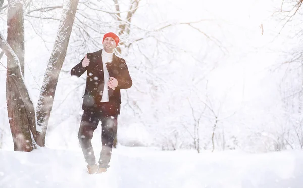 Mężczyzna na spacerze po parku. Młody człowiek w śniegu zimowym — Zdjęcie stockowe