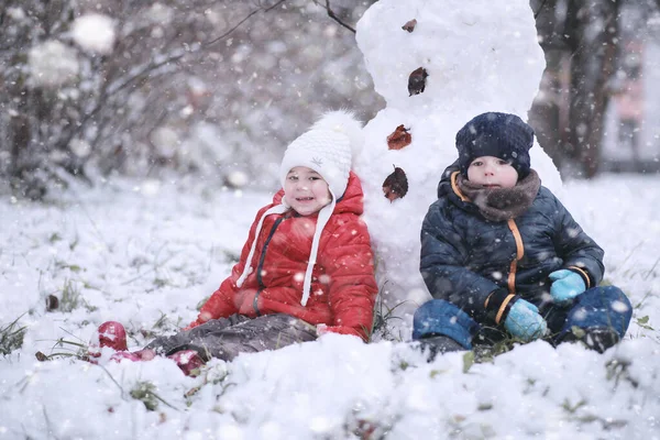 Les enfants marchent dans le parc première neige — Photo