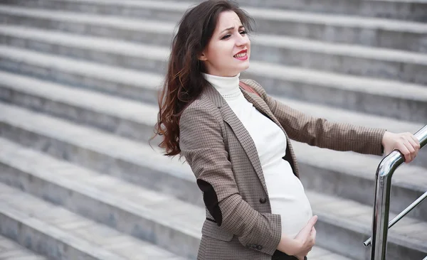 Беременная женщина чувствует боль на улице — стоковое фото