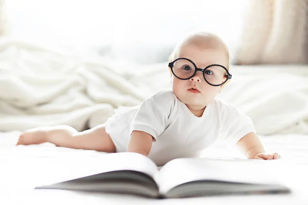 Ein neugeborenes Baby liegt auf einem weichen Bett in einer Brille. — Stockfoto