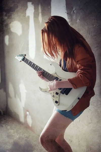 Young red-haired girl with an electric guitar. Rock musician gir — Stock Photo, Image