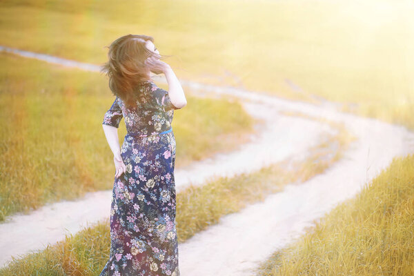 Pregnant girl in a dress in nature on a walk