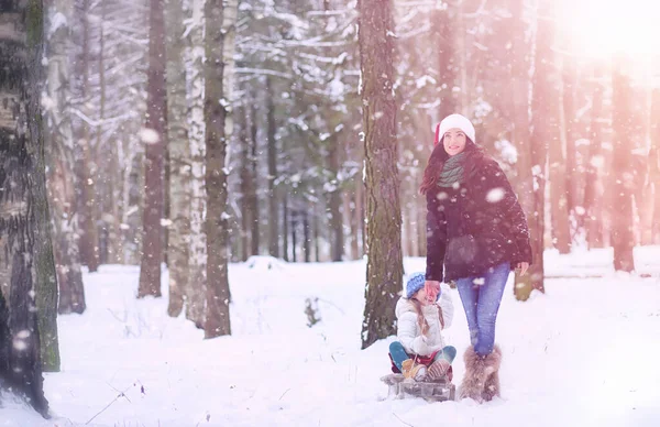 Un cuento de hadas de invierno, una joven madre y su hija montan en un trineo — Foto de Stock