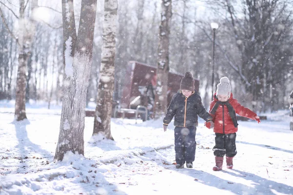 Los niños caminan en el parque primera nieve — Foto de Stock