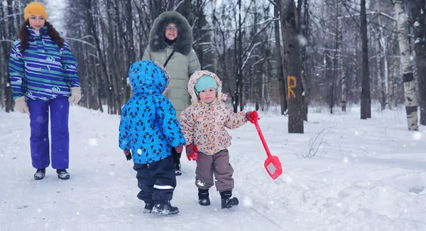 Gezin met kind wandeling in winter park besneeuwde — Stockfoto