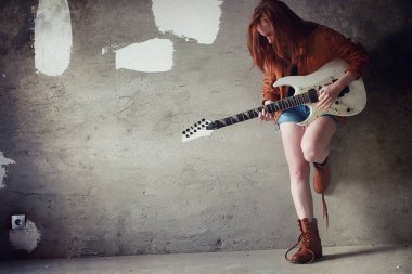 Kızıl saçlı kız bir elektro gitar ile. Rock müzisyen GIR