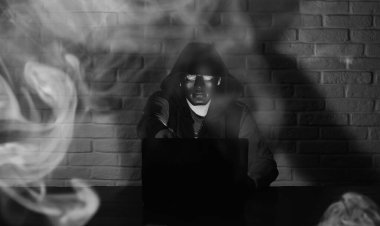 Siyah maske ve hood masada hacker